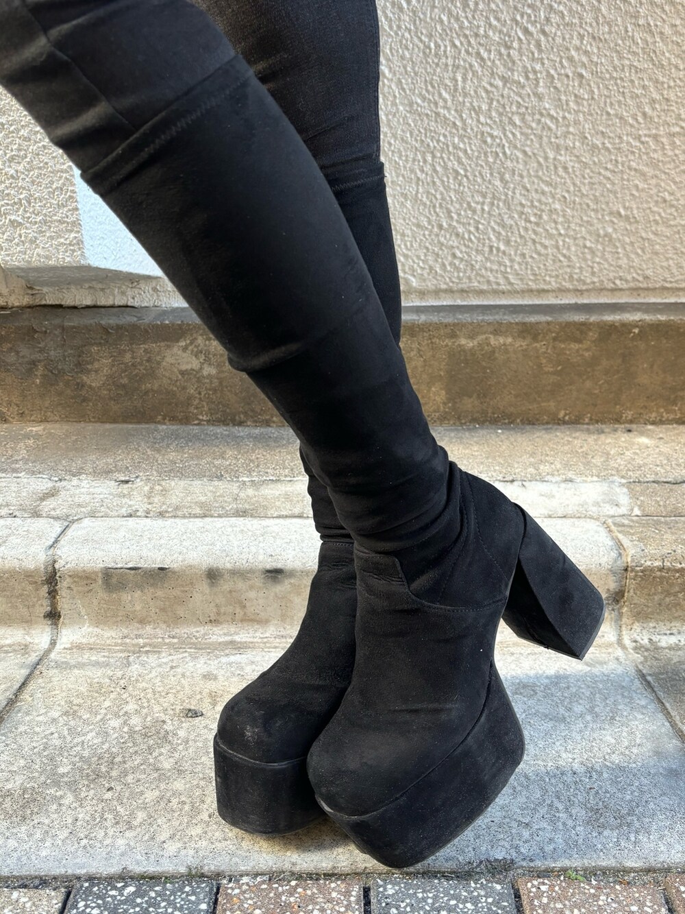 ブルー系のニット/セーター、グレー系のダウンジャケット/コート、ブラック系のデニムパンツを着用したレディースの冬コーディネートの7枚目の写真