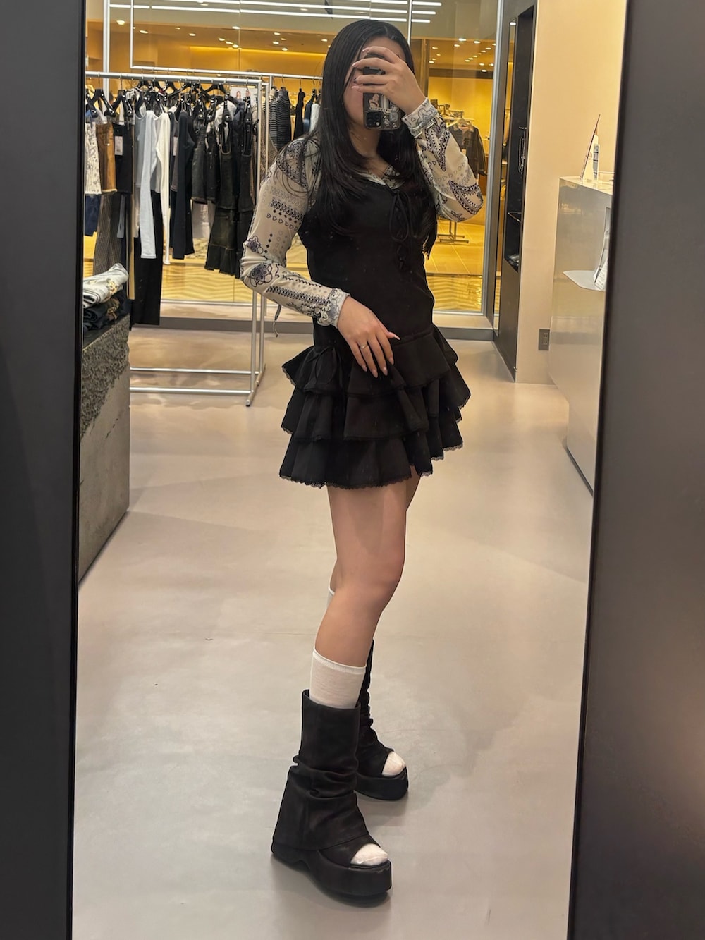 ブラック系のワンピース、ブラック系のサンダル、ホワイト系のTシャツ/カットソーを着用したレディースの春コーディネートの2枚目の写真