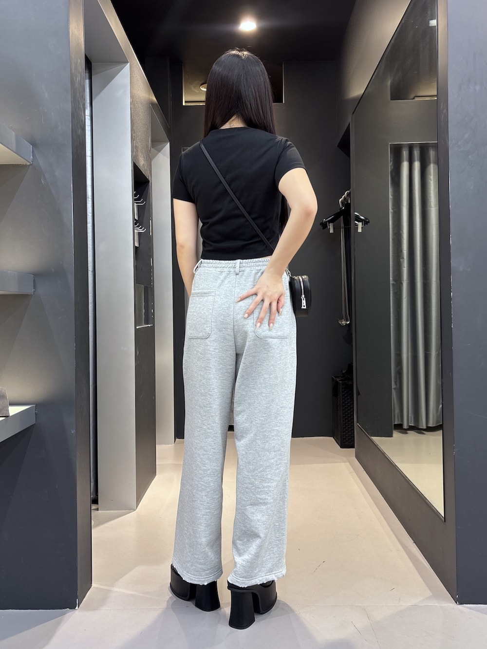 ブラック系のサンダル、ブラック系のスウェットパンツ、ブラック系のショルダーバッグを着用したレディースの夏コーディネートの3枚目の写真