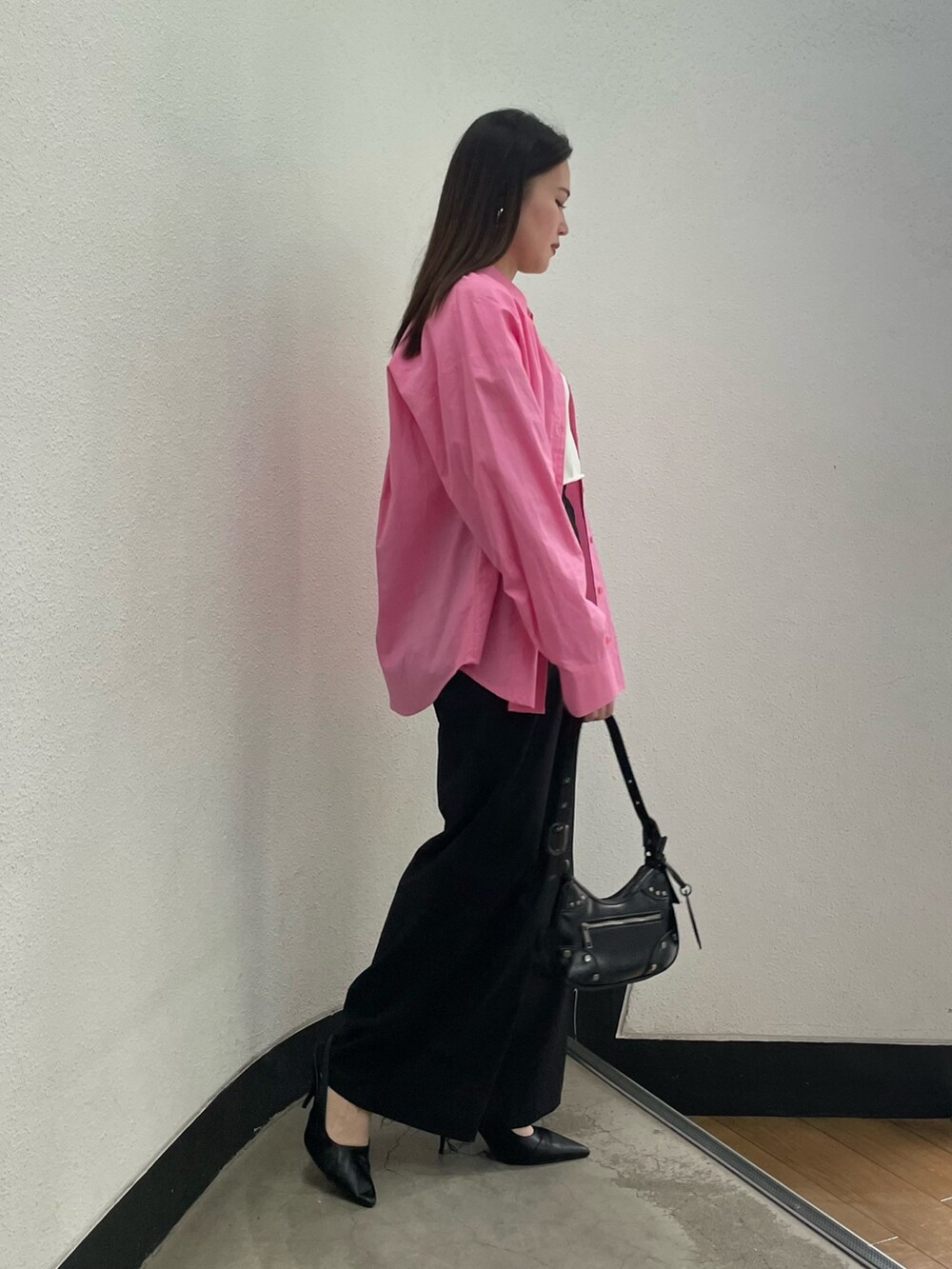 ブラック系のパンプス、ブラック系のハンドバッグ、ピンク系のシャツ/ブラウスを着用したレディースの冬コーディネートの2枚目の写真