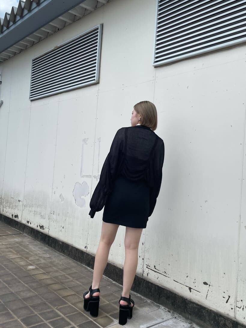 ブラック系のスカート、ブラック系のサンダル、ホワイト系のニット/セーターを着用したレディースの秋コーディネートの3枚目の写真