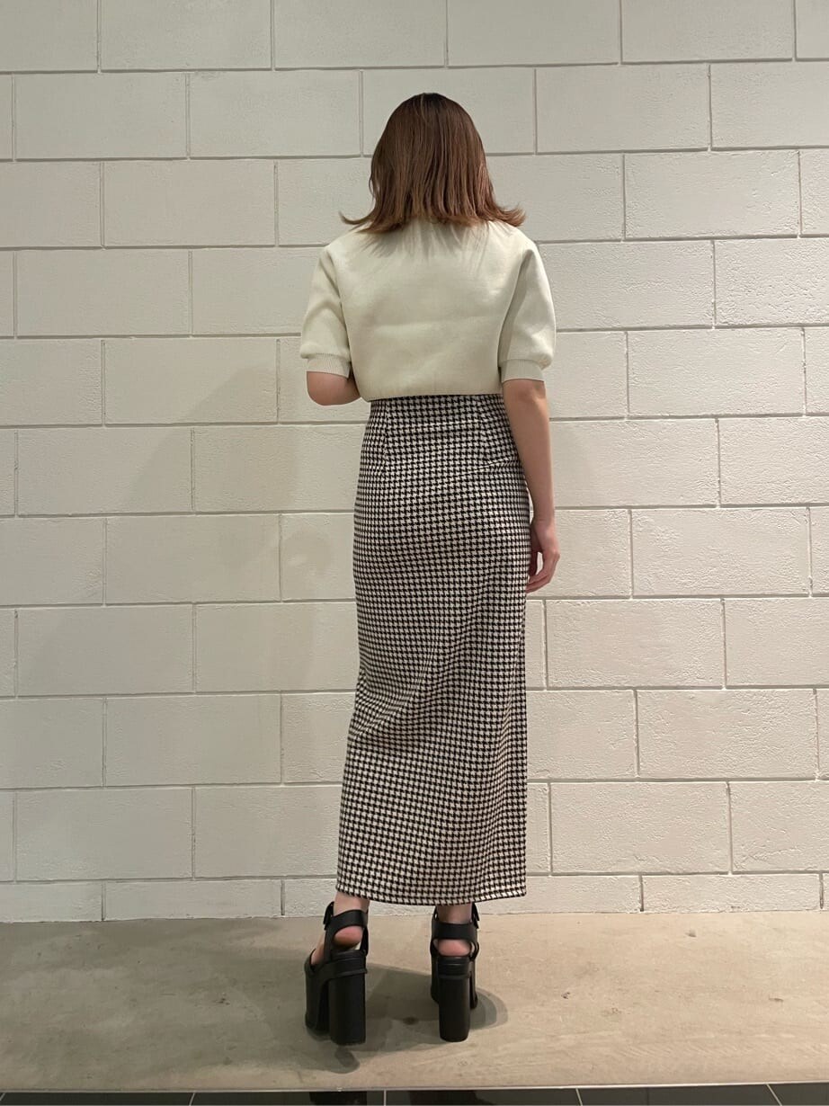ブラック系のサンダル、ホワイト系のニット/セーター、その他のスカートを着用したレディースの春コーディネートの3枚目の写真