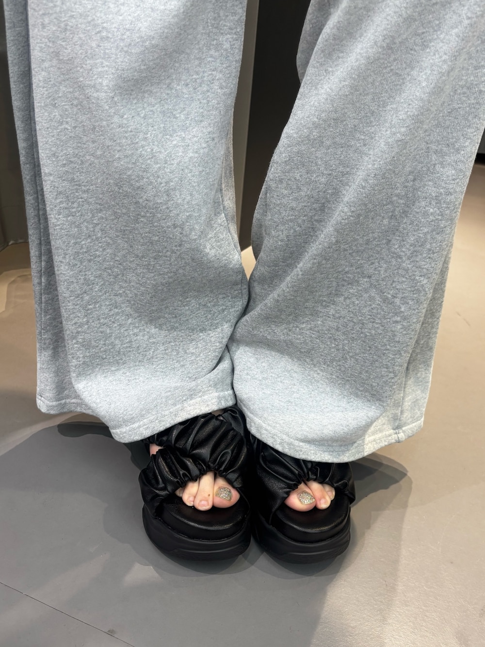 ブラック系のサンダル、グレー系のスウェットパンツ、グレー系のニット/セーターを着用したレディースの夏コーディネートの6枚目の写真