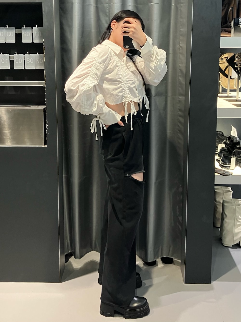 ブラック系のスウェットパンツ、ホワイト系のシャツ/ブラウス、ブラウン系のブーツを着用したレディースの秋コーディネートの2枚目の写真