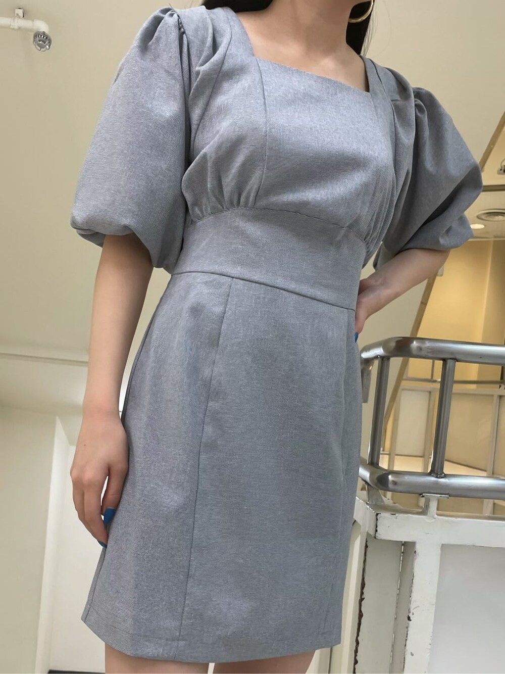 グレー系のワンピース、ゴールド系のピアス(両耳用)を着用したレディースの夏コーディネートの4枚目の写真