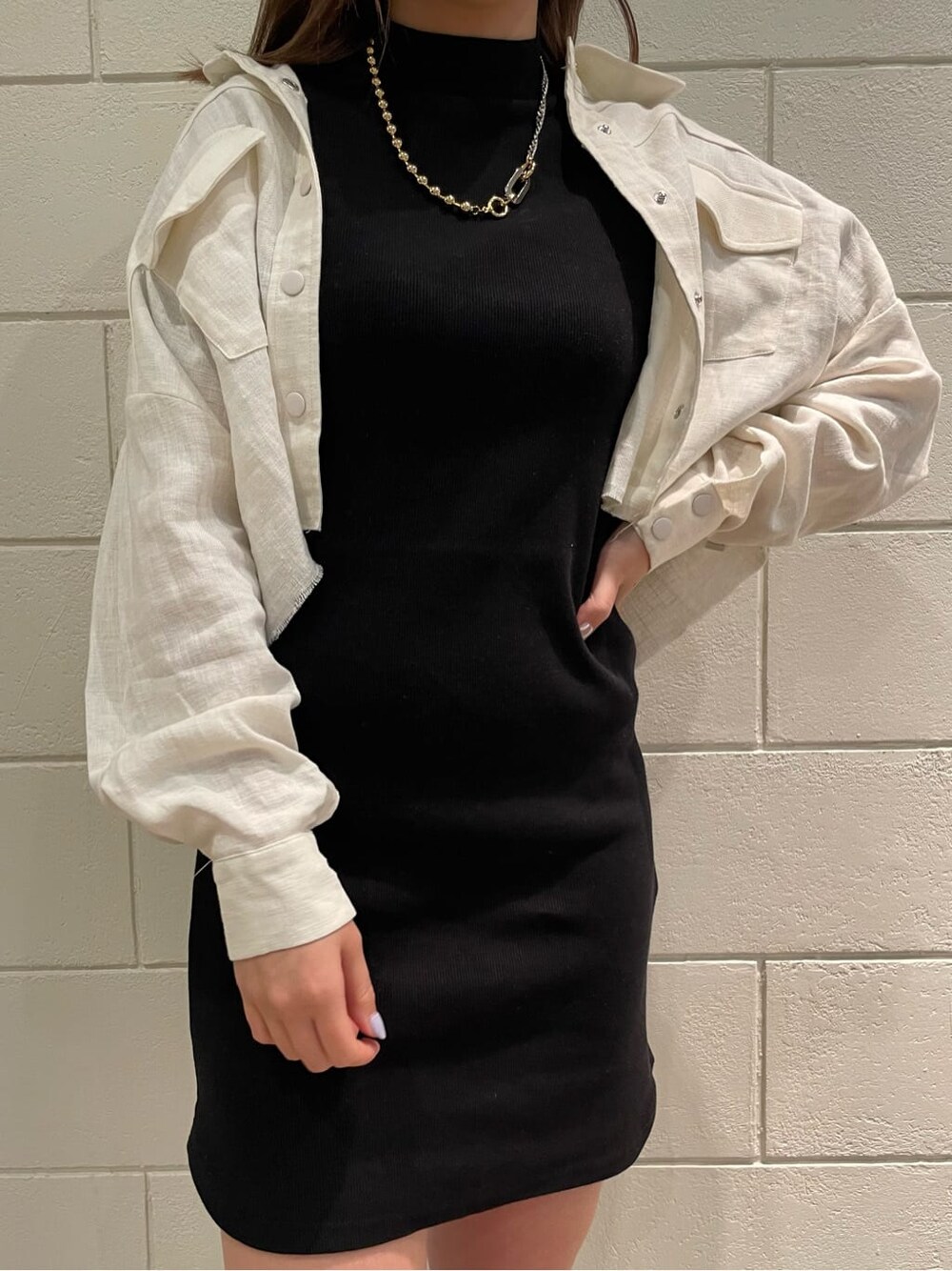 ブラック系のワンピース、ホワイト系のブルゾン、ブラック系のサンダルを着用したレディースの春コーディネートの5枚目の写真