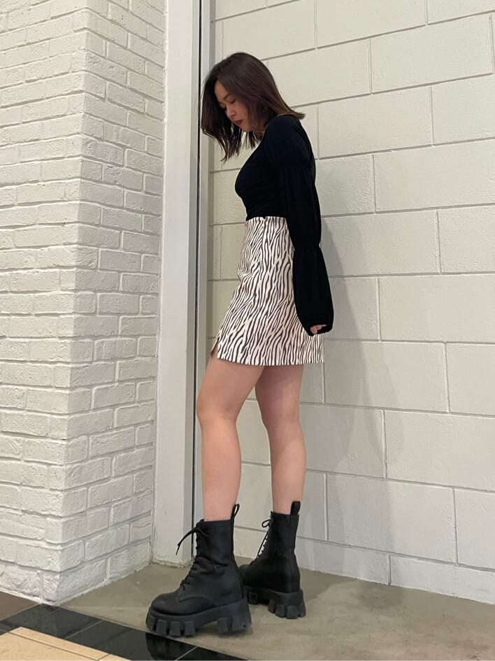 ブラック系のブーツ、ブラック系のTシャツ/カットソー、その他のスカートを着用したレディースの春コーディネートの2枚目の写真