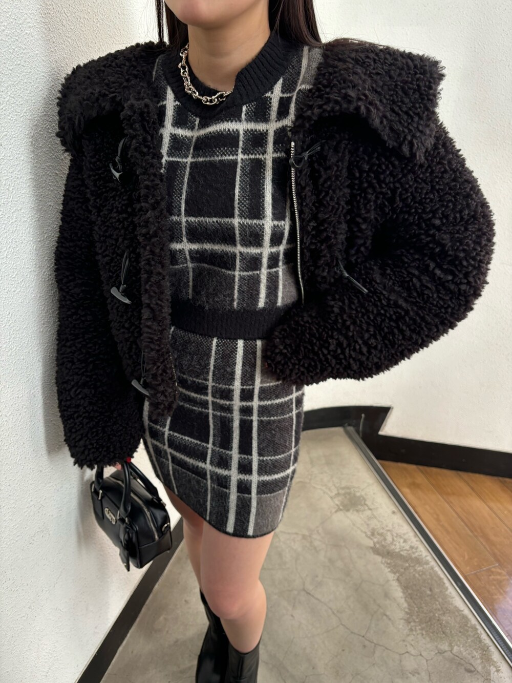 ブラック系のブルゾン、ブラック系のニット/セーター、ブラック系のスカートを着用したレディースの冬コーディネートの6枚目の写真