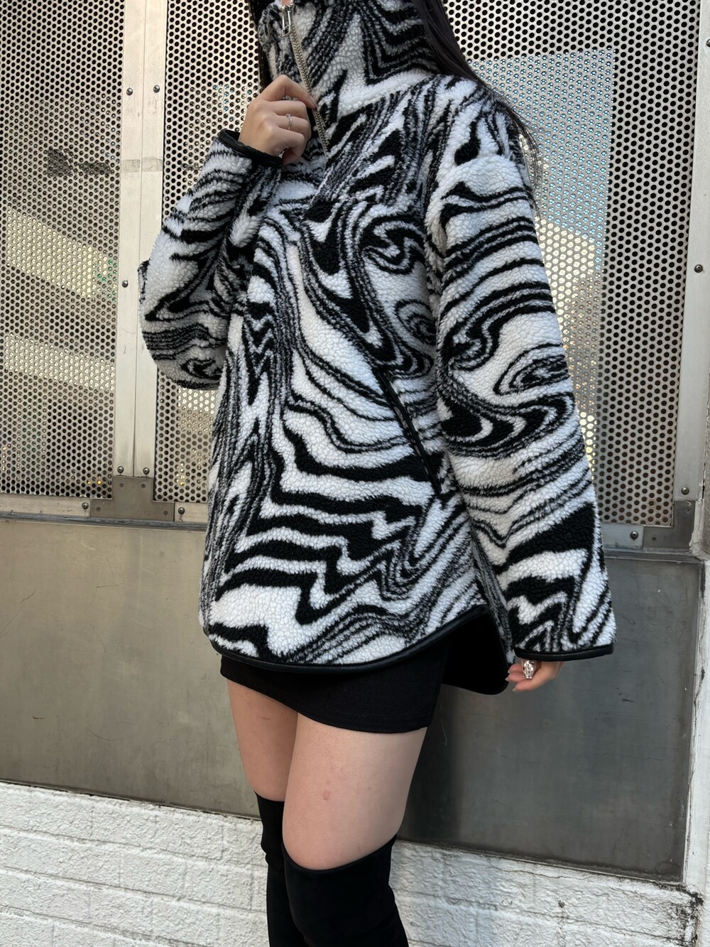 ブラック系のスカート、ブラック系のブーツ、ブラック系のTシャツ/カットソーを着用したレディースの秋コーディネートの7枚目の写真