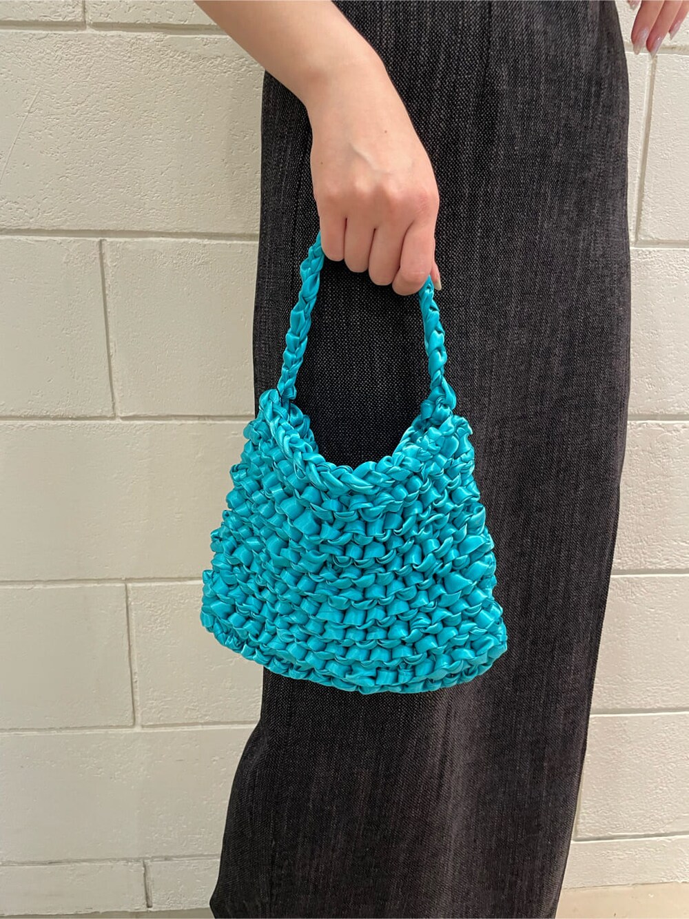 ブラック系のサンダル、ブラック系のスカート、ブルー系のハンドバッグを着用したレディースの春コーディネートの8枚目の写真