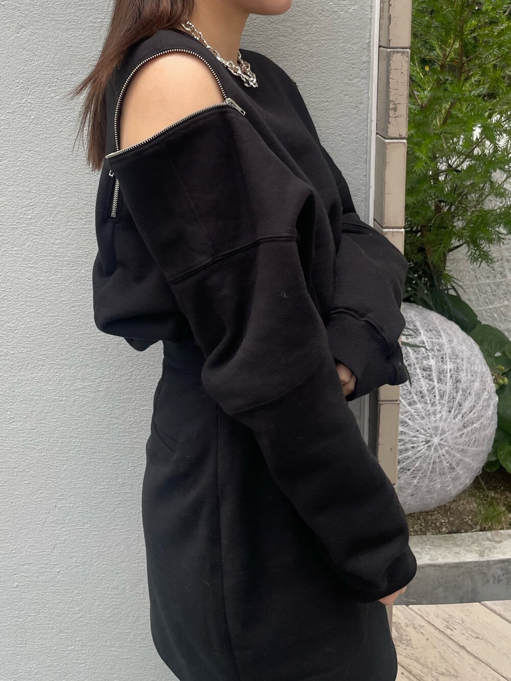 ブラック系のTシャツ/カットソー、ブラック系のスカート、ブラック系のブーツを着用したレディースの冬コーディネートの4枚目の写真