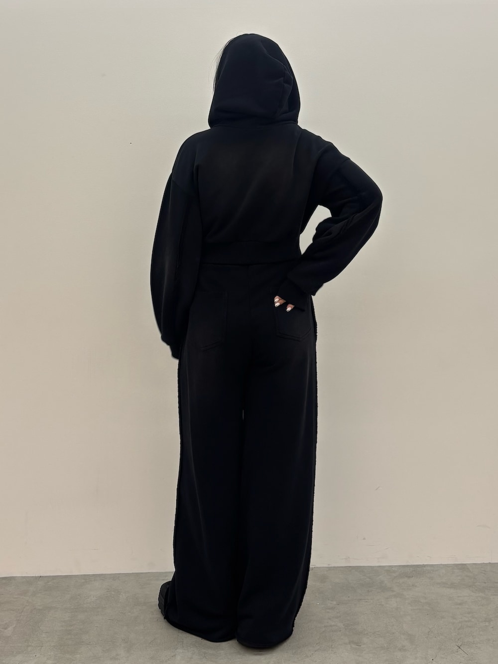 ブラック系のスニーカー、ブラック系のスウェットパンツ、ブラック系のパーカーを着用したレディースの夏コーディネートの3枚目の写真