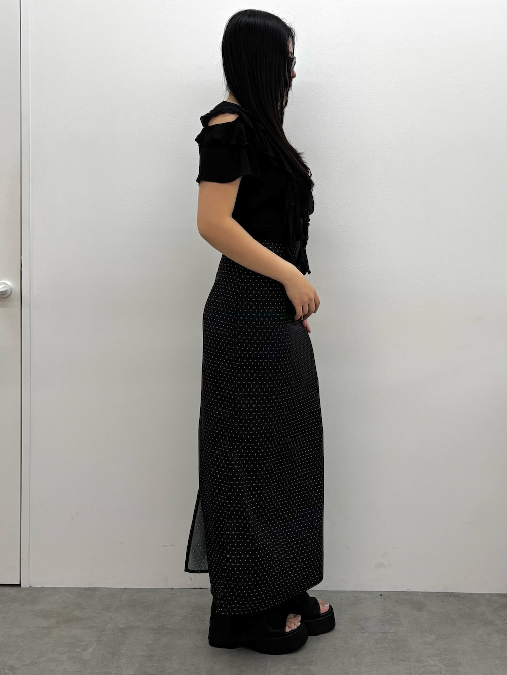 ブラック系のサンダル、ブラック系のスカート、ブラック系のTシャツ/カットソーを着用したレディースの春コーディネートの2枚目の写真