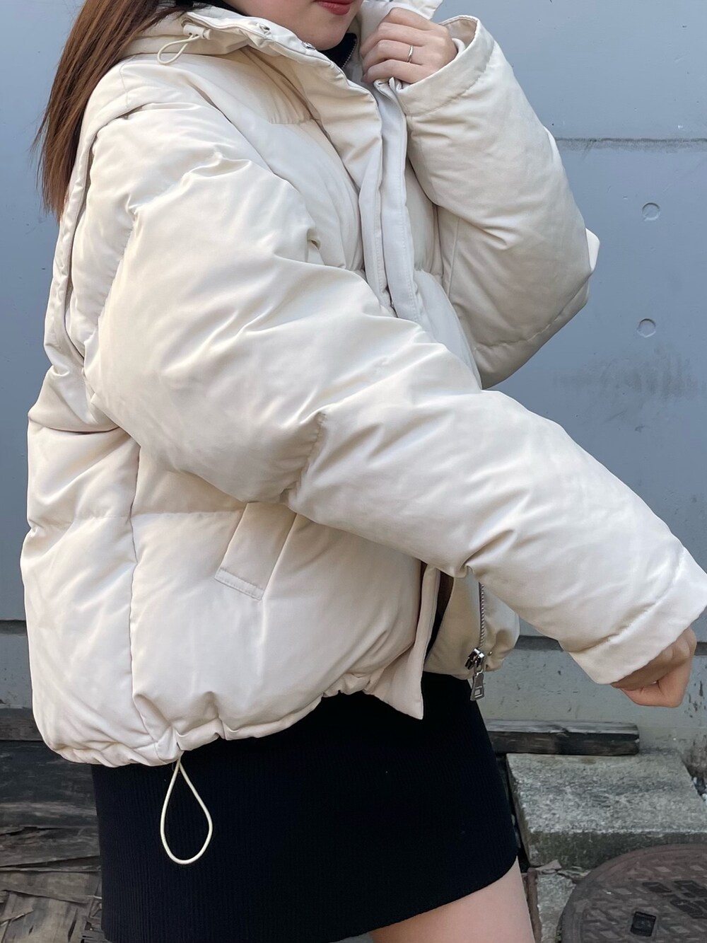 ホワイト系のダウンジャケット/コート、ブラック系のワンピース、ブラック系のブーツを着用したレディースの冬コーディネートの4枚目の写真