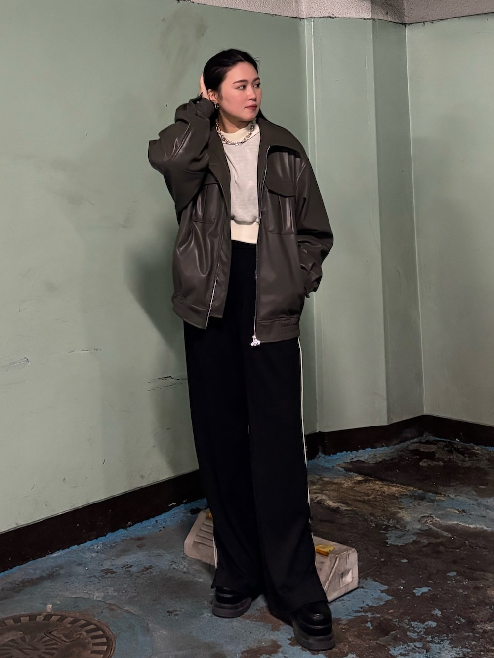 ブラック系のスラックス、ブラック系のローファー、グレー系のブルゾンを着用したレディースの冬コーディネートの2枚目の写真