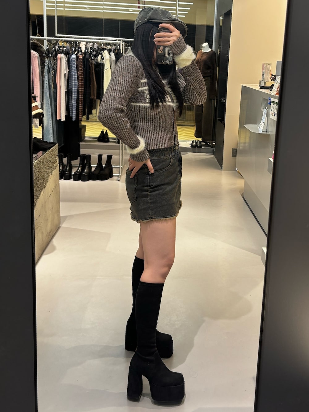 ブラック系のブーツ、ブラウン系のスカート、グレー系のニット/セーターを着用したレディースの冬コーディネートの2枚目の写真