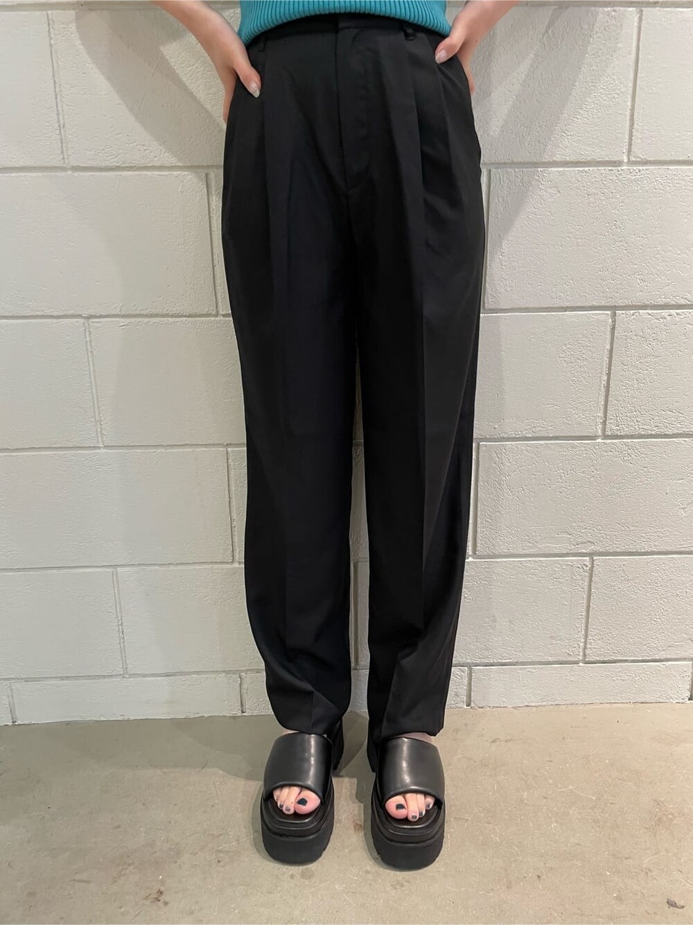 ブラック系のサンダル、ブラック系のスラックス、ブルー系のニット/セーターを着用したレディースの春コーディネートの7枚目の写真