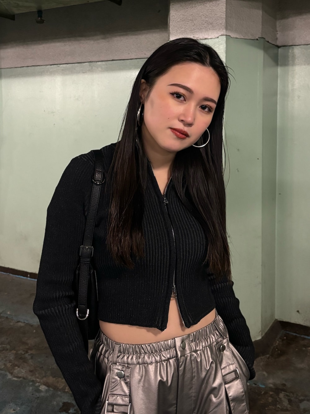 シルバー系のその他パンツ、ブラック系のニット/セーター、ブラック系のスニーカーを着用したレディースの冬コーディネートの4枚目の写真