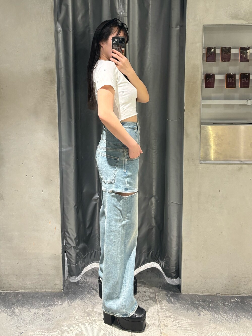 ブルー系のデニムパンツ、ブラック系のサンダル、ホワイト系のTシャツ/カットソーを着用したレディースの春コーディネートの2枚目の写真