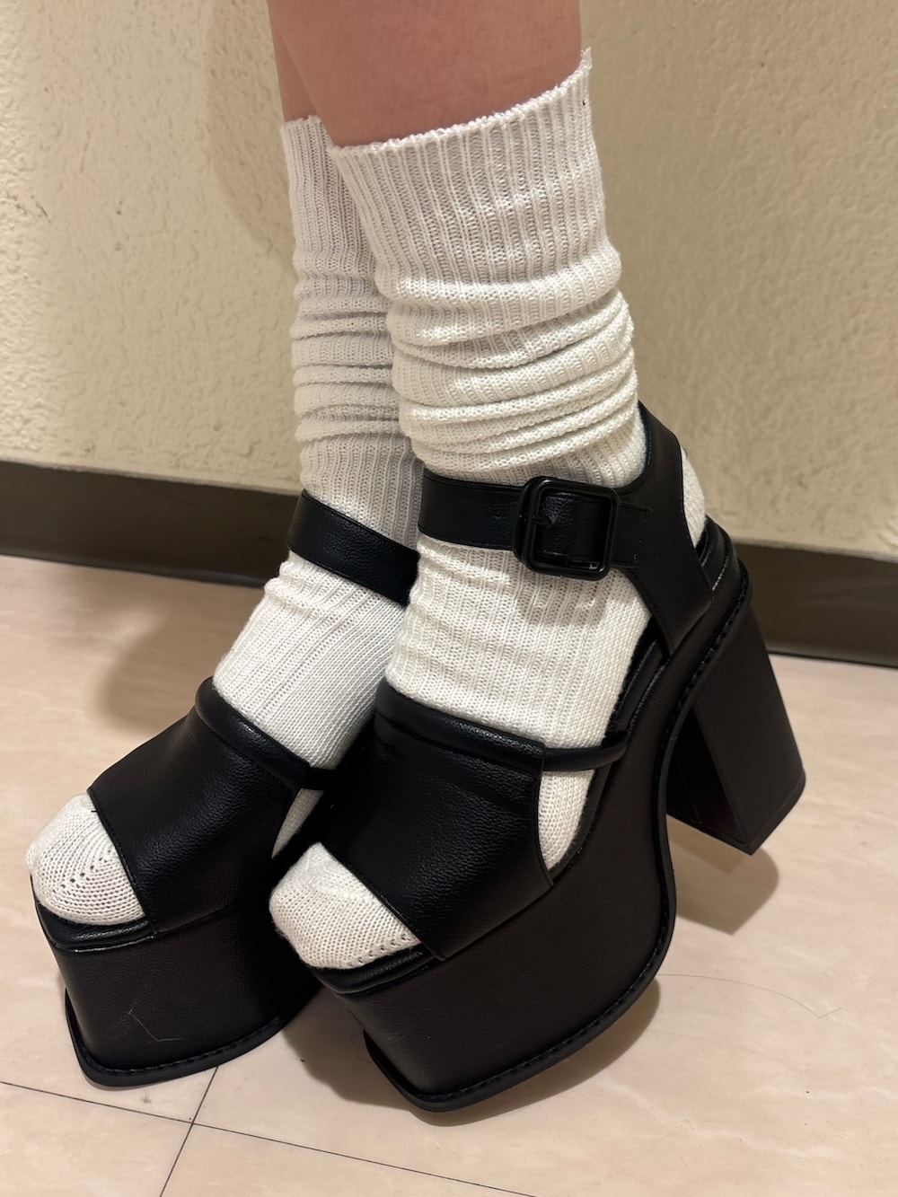 ブラック系のサンダル、ベージュ系のスカート、ブラック系のニット/セーターを着用したレディースの春コーディネートの9枚目の写真