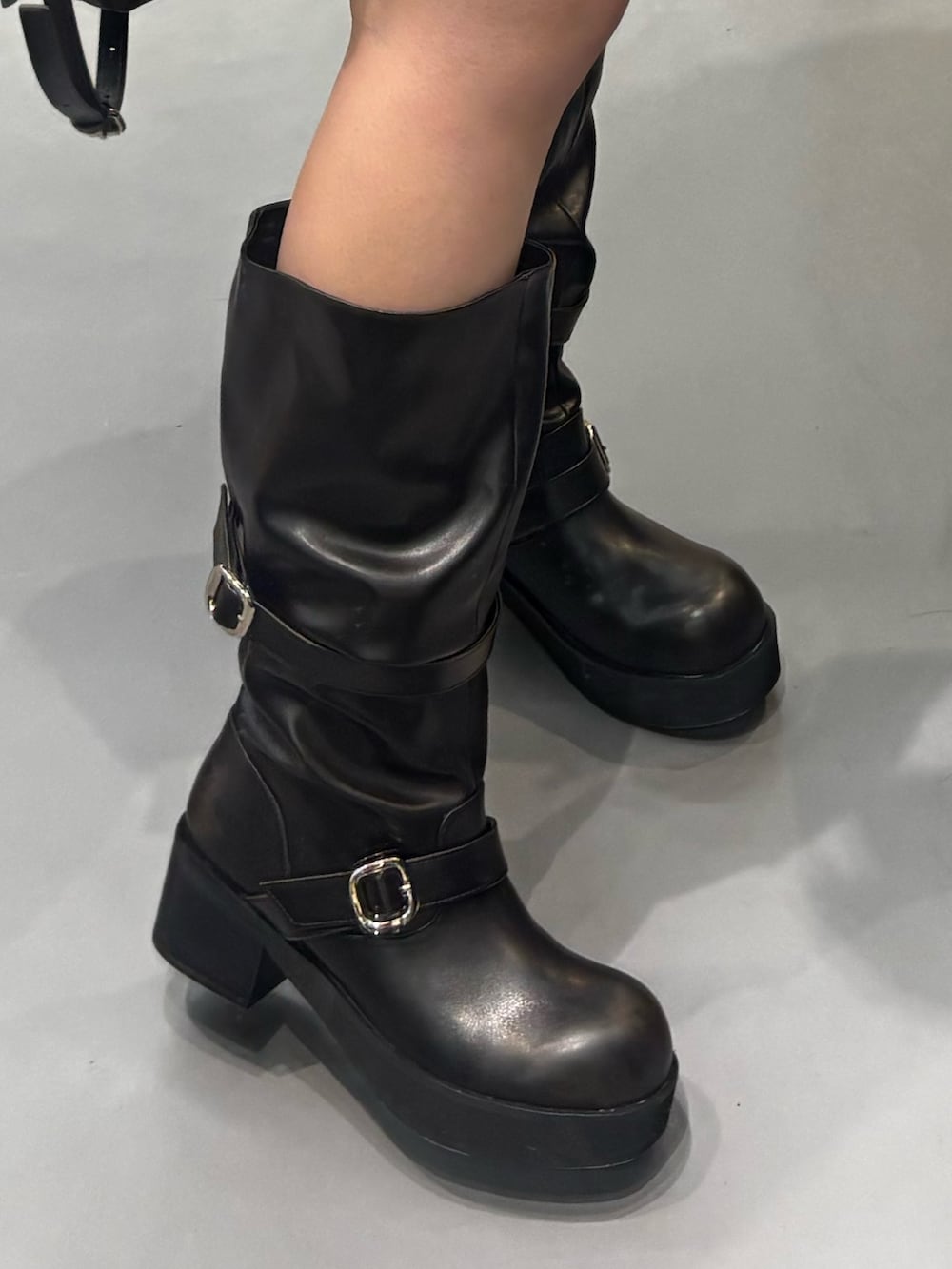 ブラック系のブーツ、ブルー系のその他パンツ、ブラック系のニット/セーターを着用したレディースの冬コーディネートの5枚目の写真