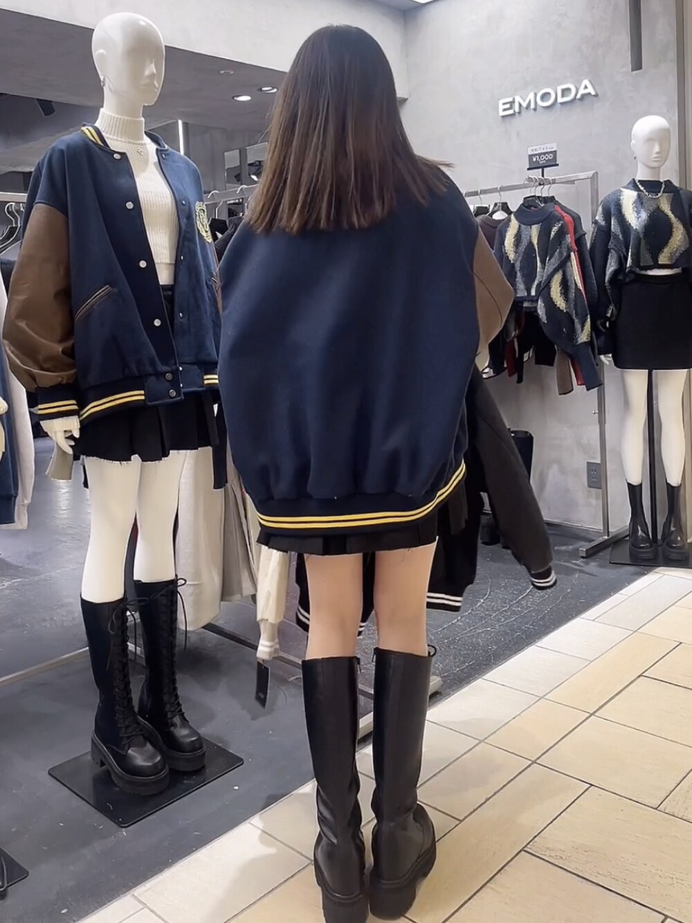 ブラック系のニット/セーター、ブラック系のスカート、ブルー系のブルゾンを着用したレディースの秋コーディネートの3枚目の写真