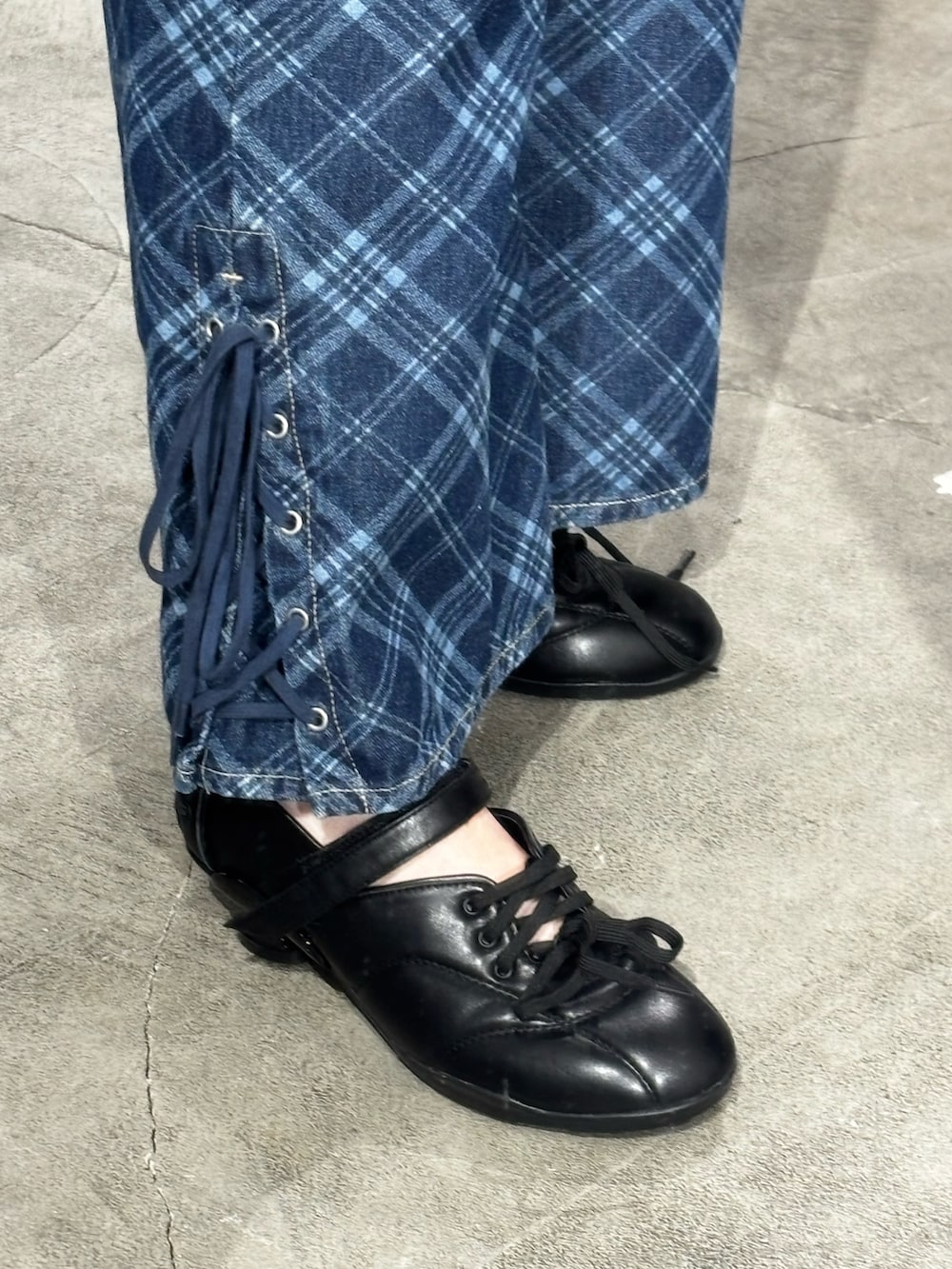 ブラック系のスニーカー、ブルー系のデニムパンツを着用したレディースの冬コーディネートの5枚目の写真