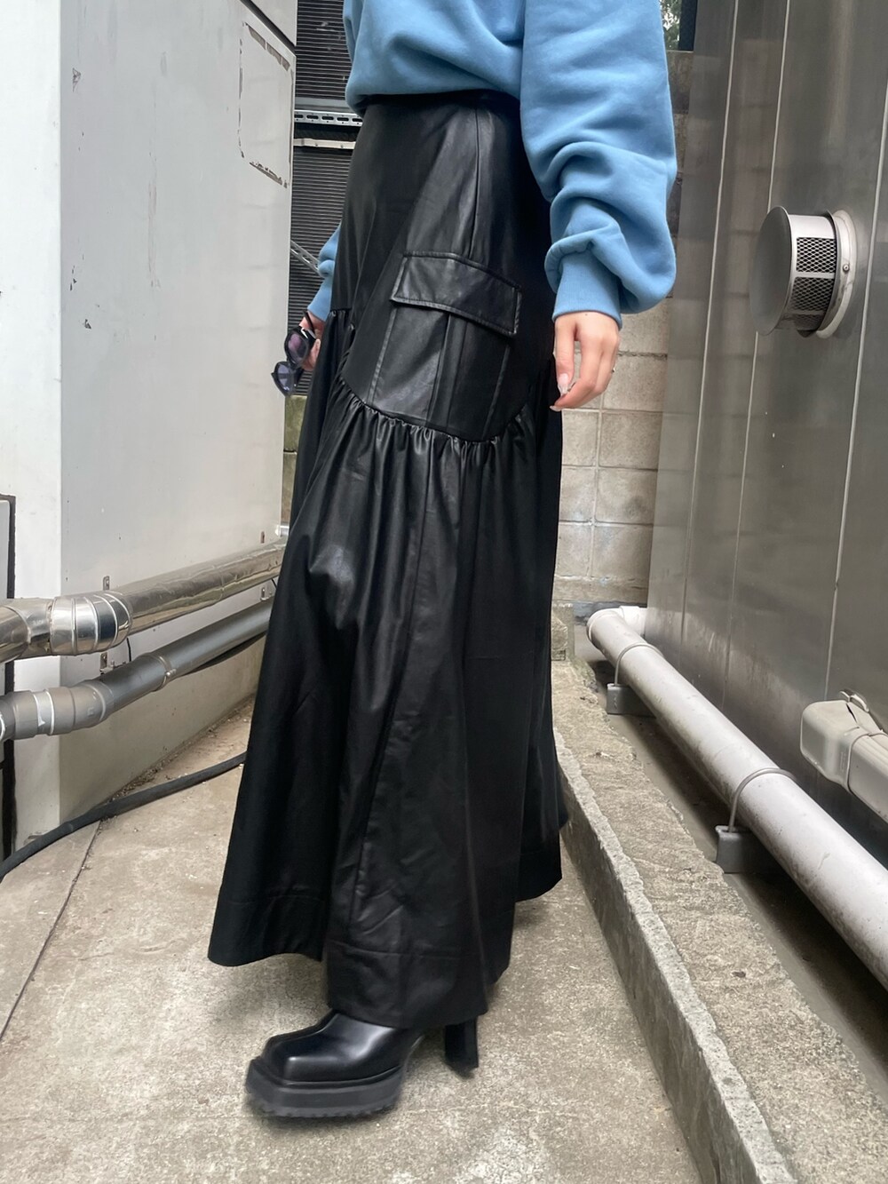 ブラック系のブーツ、ブラック系のスカート、ブルー系のスウェットを着用したレディースの秋コーディネートの5枚目の写真