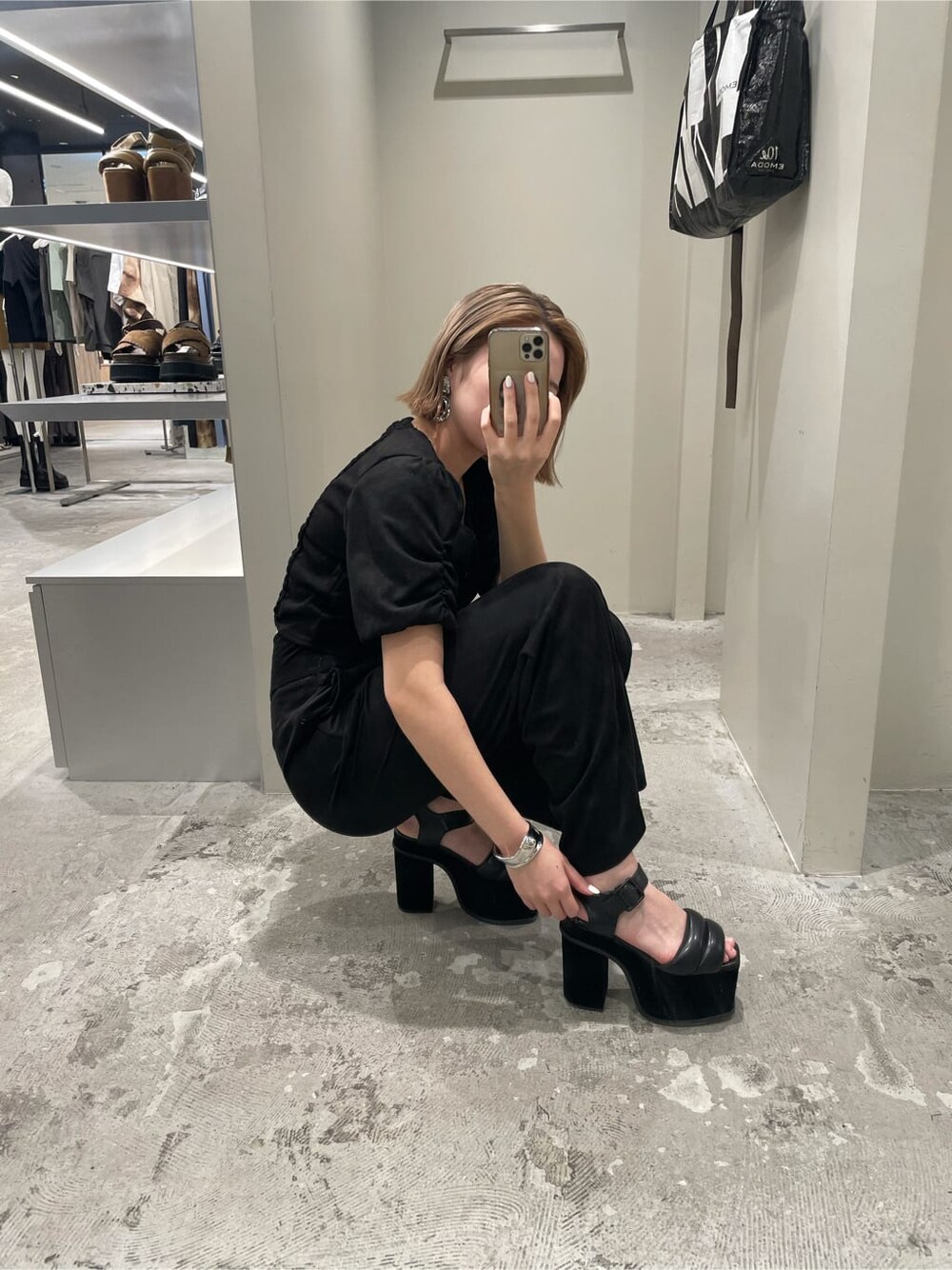 ブラウン系のハンドバッグ、ブラック系のその他パンツ、ブラック系のサンダルを着用したレディースの夏コーディネートの2枚目の写真