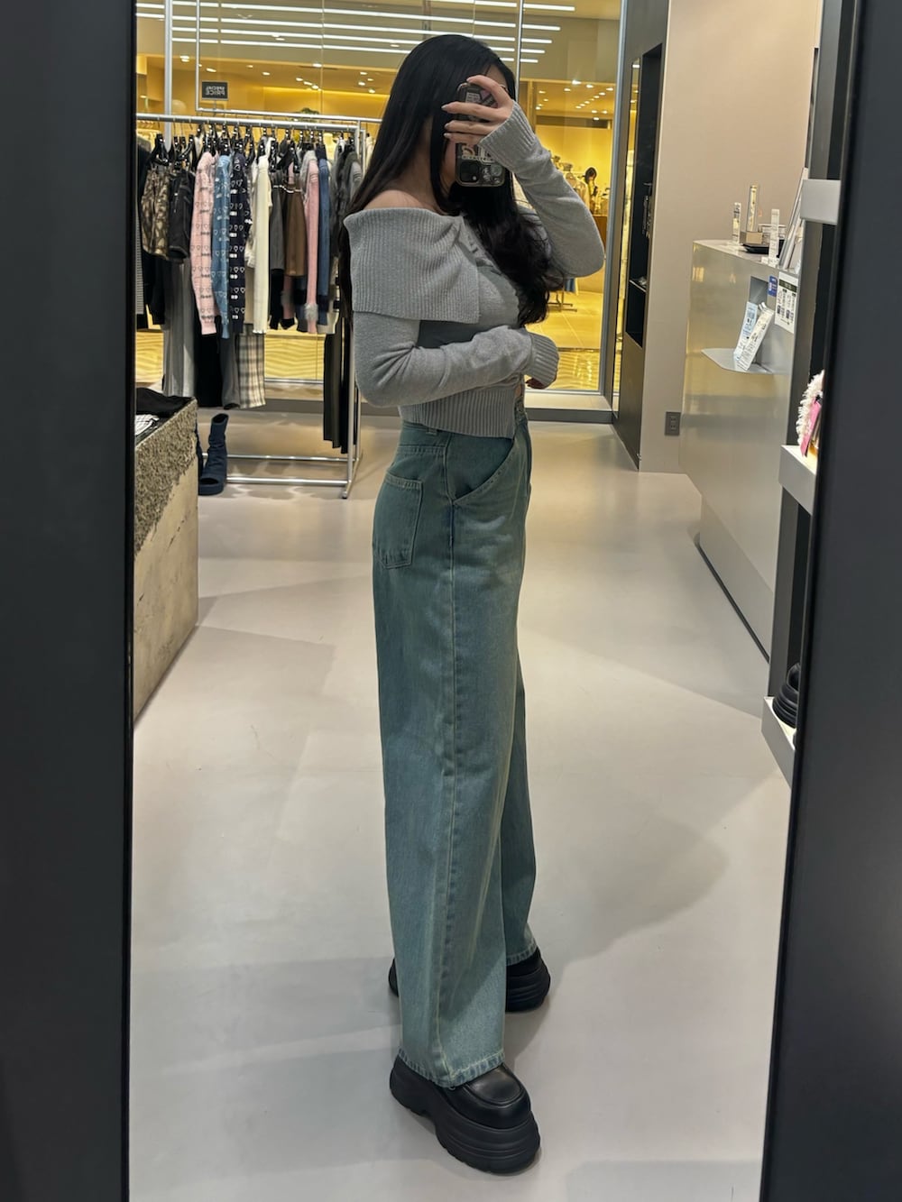 ブラック系のローファー、ベージュ系のデニムパンツを着用したレディースの冬コーディネートの2枚目の写真