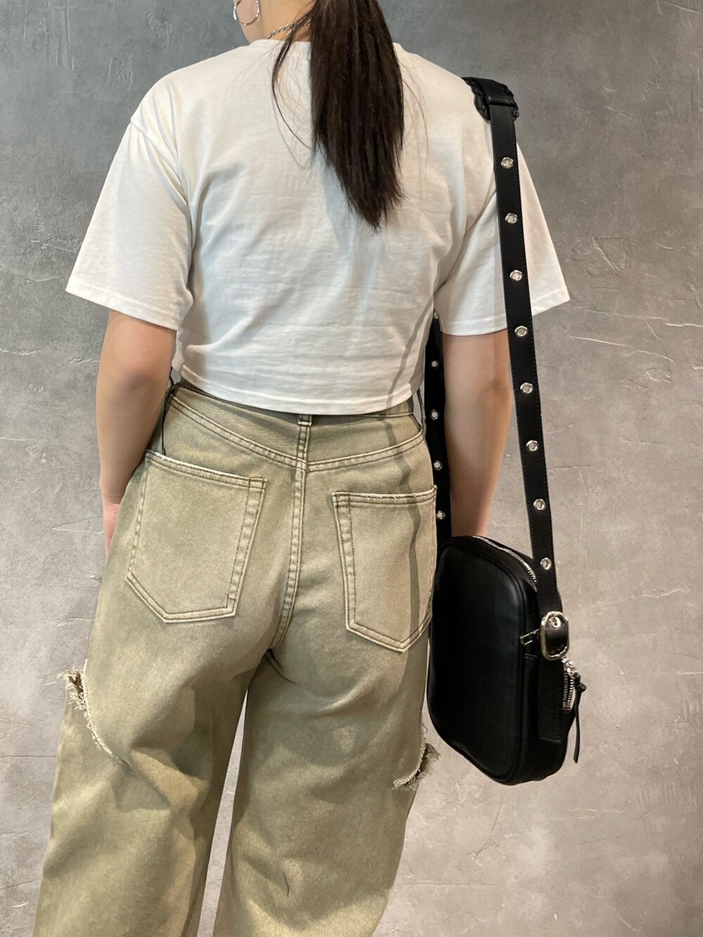 ベージュ系のデニムパンツ、グレー系のTシャツ/カットソー、ブラック系のショルダーバッグを着用したレディースの春コーディネートの6枚目の写真