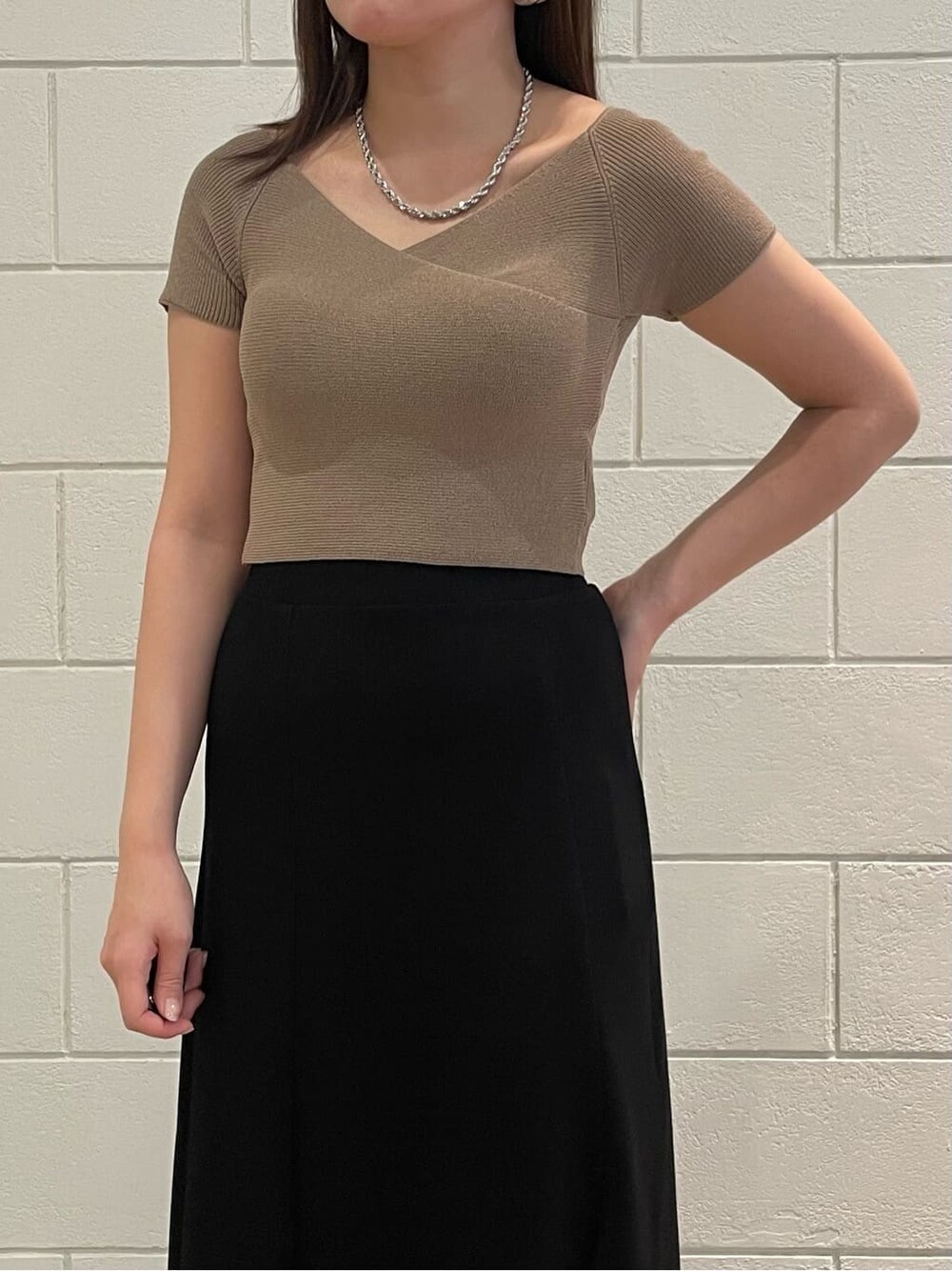 ベージュ系のニット/セーター、ブラック系のスカート、ブラック系のサンダルを着用したレディースの夏コーディネートの4枚目の写真