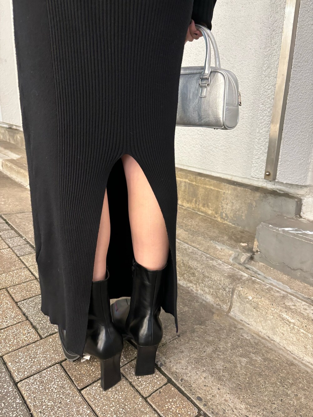 ブラック系のワンピース、ブラック系のブーツ、シルバー系のハンドバッグを着用したレディースの秋コーディネートの9枚目の写真