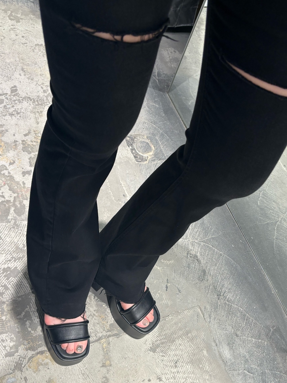 ホワイト系のTシャツ/カットソー、ブラック系のデニムパンツ、ブラック系のサンダルを着用したレディースの春コーディネートの6枚目の写真