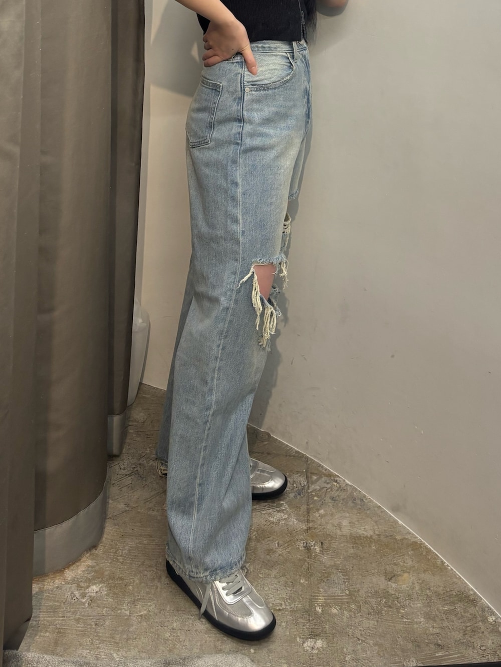 シルバー系のスニーカー、ブルー系のデニムパンツ、ブラック系のニット/セーターを着用したレディースの春コーディネートの4枚目の写真