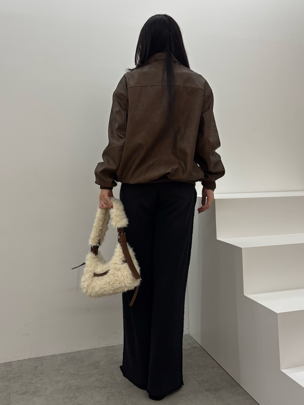 ブラック系のスウェットパンツ、ブラック系のブルゾン、ブラック系のショルダーバッグを着用したレディースの秋コーディネートの3枚目の写真