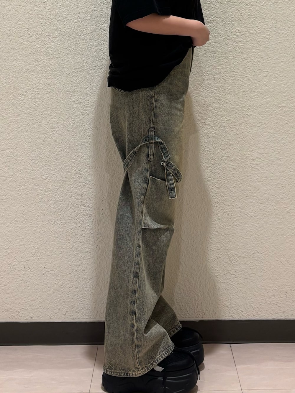 ブラック系のスニーカー、ベージュ系のデニムパンツ、ブラック系のTシャツ/カットソーを着用したレディースの春コーディネートの8枚目の写真