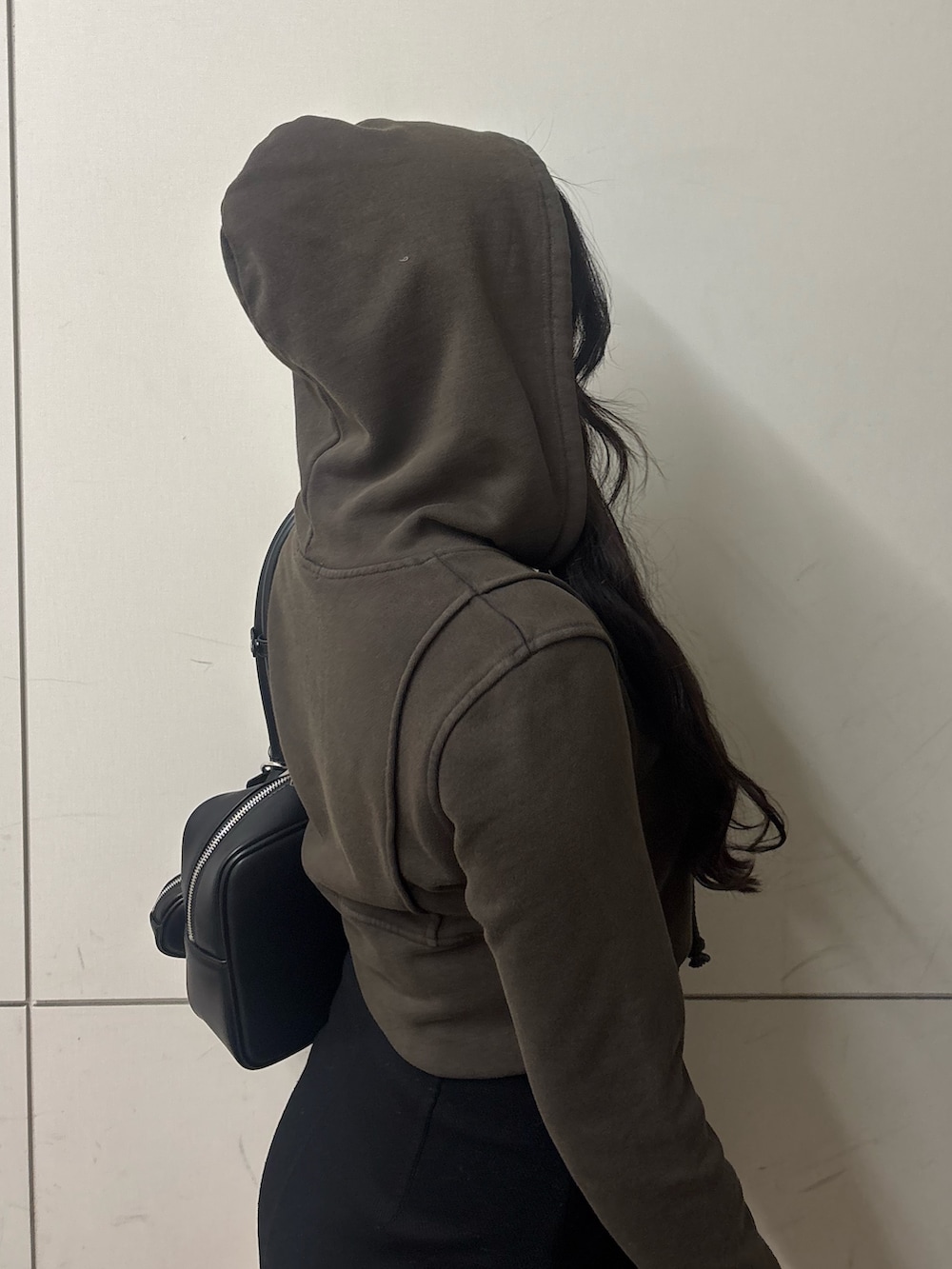 ブラック系のスカート、ブラック系のブーツ、ブラック系のハンドバッグを着用したレディースの春コーディネートの4枚目の写真