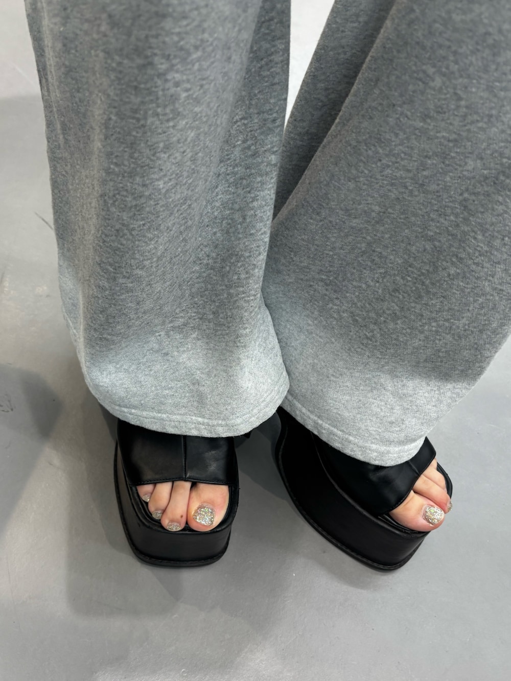 ブラック系のサンダル、グレー系のスウェットパンツ、ブラック系のシャツ/ブラウスを着用したレディースの春コーディネートの5枚目の写真