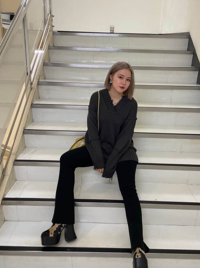 イエロー系のハンドバッグ、その他のブーツ、グレー系のニット/セーターを着用したレディースの秋コーディネートの2枚目の写真