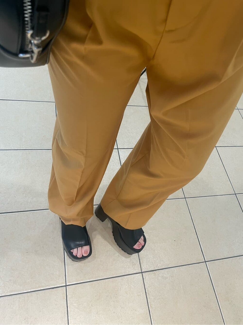 ブラック系のショルダーバッグ、オレンジ系のその他パンツ、ブラック系のサンダルを着用したレディースの夏コーディネートの9枚目の写真