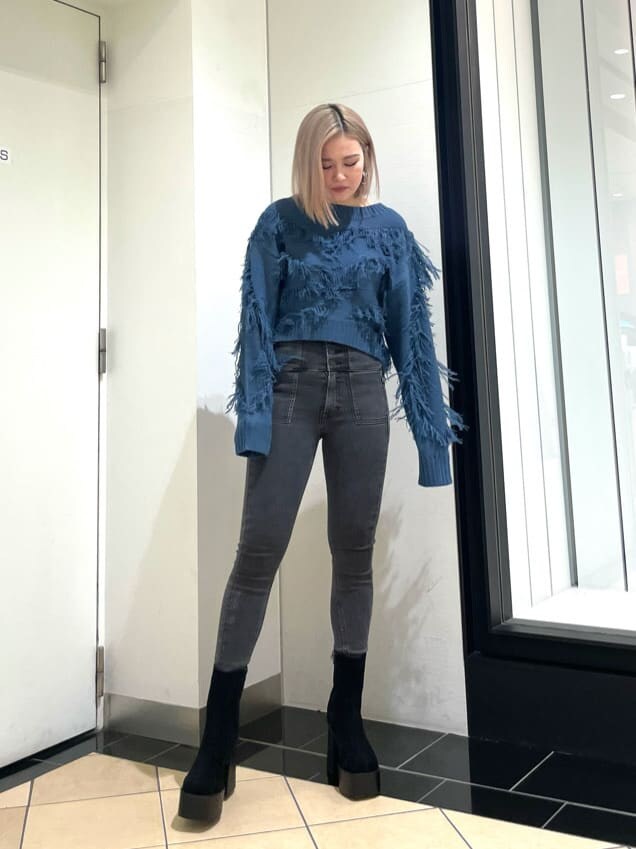 ブラック系のブーツ、グレー系のデニムパンツ、ブラック系のムートンコートを着用したレディースの冬コーディネートの3枚目の写真