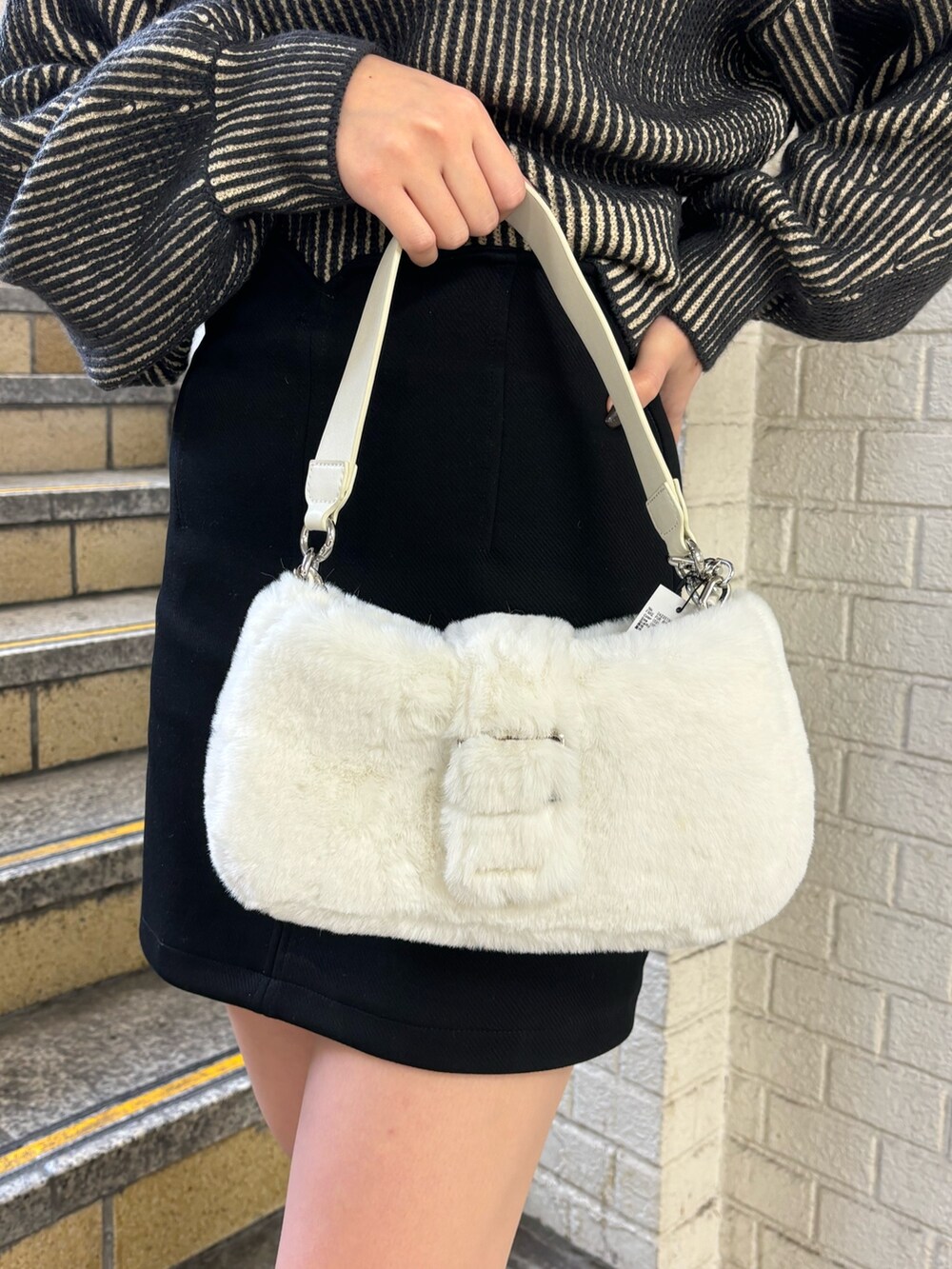 ブラック系のニット/セーター、ブラック系のスカート、その他のブーツを着用したレディースの秋コーディネートの7枚目の写真