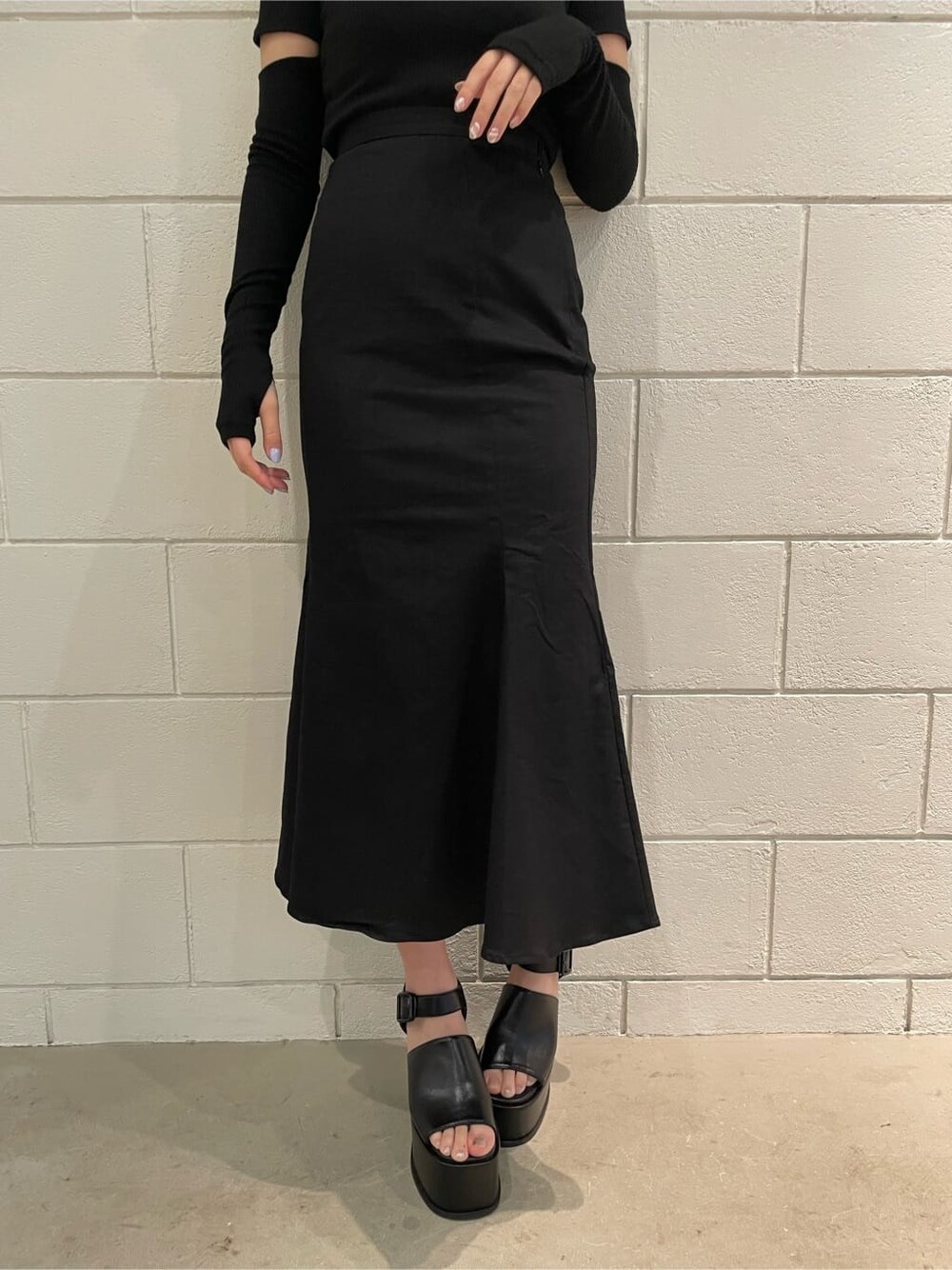 ブラック系のサンダル、ブラック系のスカート、ブラック系のTシャツ/カットソーを着用したレディースの春コーディネートの6枚目の写真