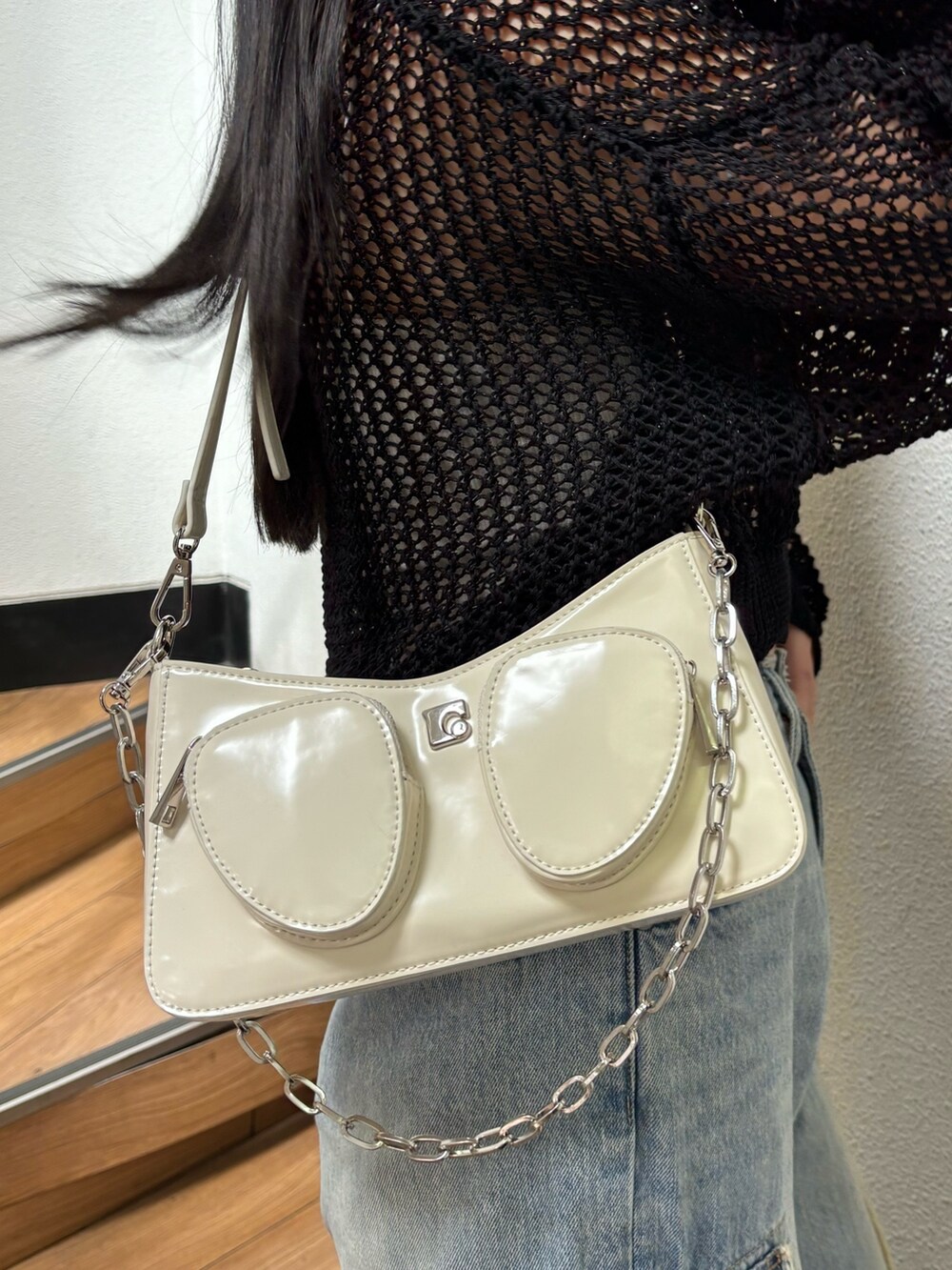 ブラック系のニット/セーター、ブルー系のデニムパンツを着用したレディースの春コーディネートの4枚目の写真