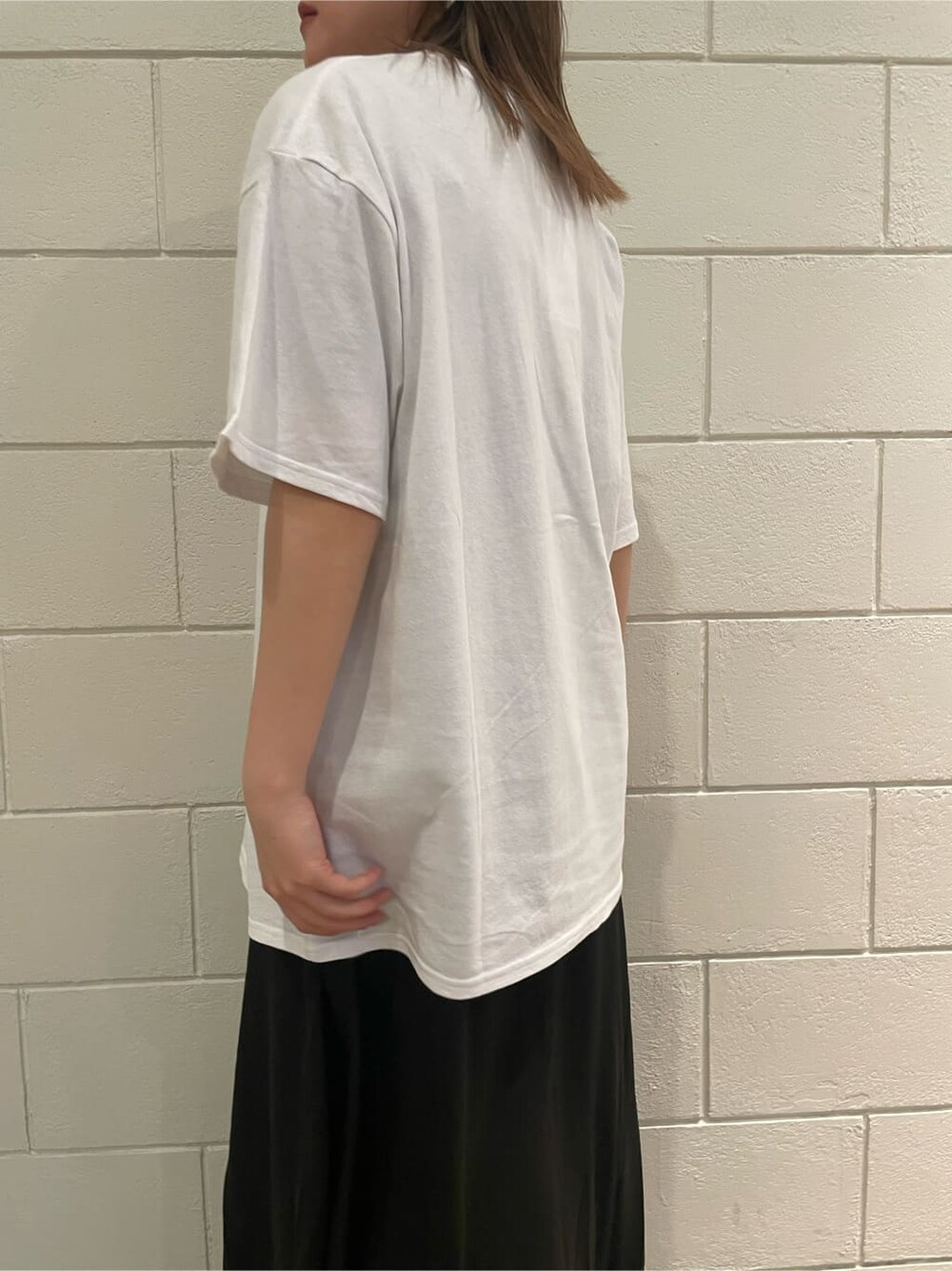 ブラック系のサンダル、ブラック系のワンピース、ホワイト系のTシャツ/カットソーを着用したレディースの春コーディネートの5枚目の写真