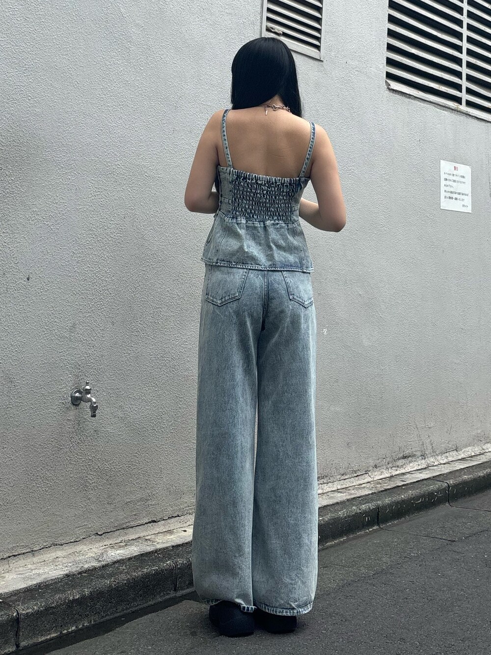 ブラック系のサンダル、ブルー系のデニムパンツ、ブルー系のキャミソールを着用したレディースの夏コーディネートの2枚目の写真