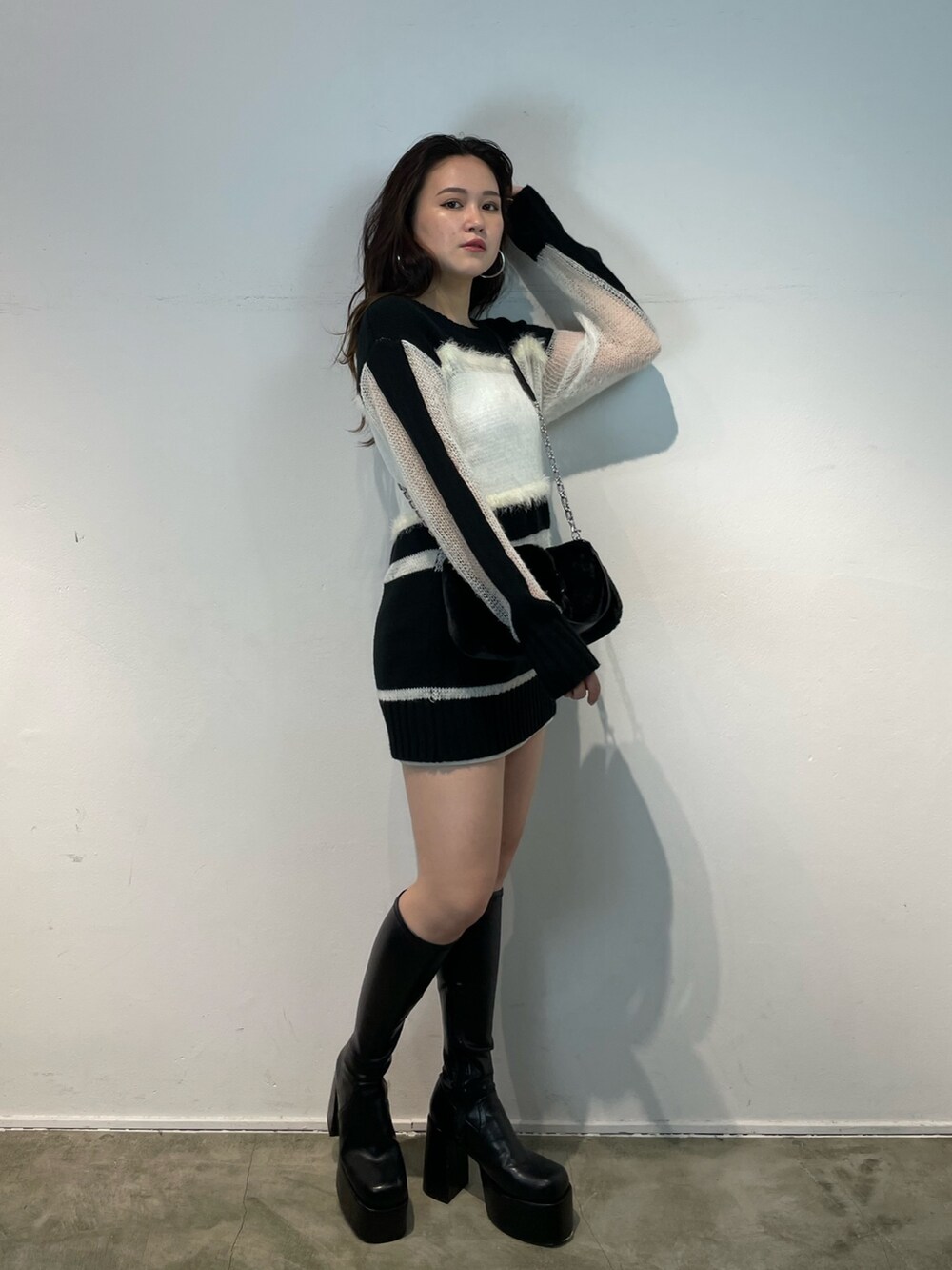 その他のブーツ、その他のニット/セーター、ブラック系のハンドバッグを着用したレディースの夏コーディネートの2枚目の写真