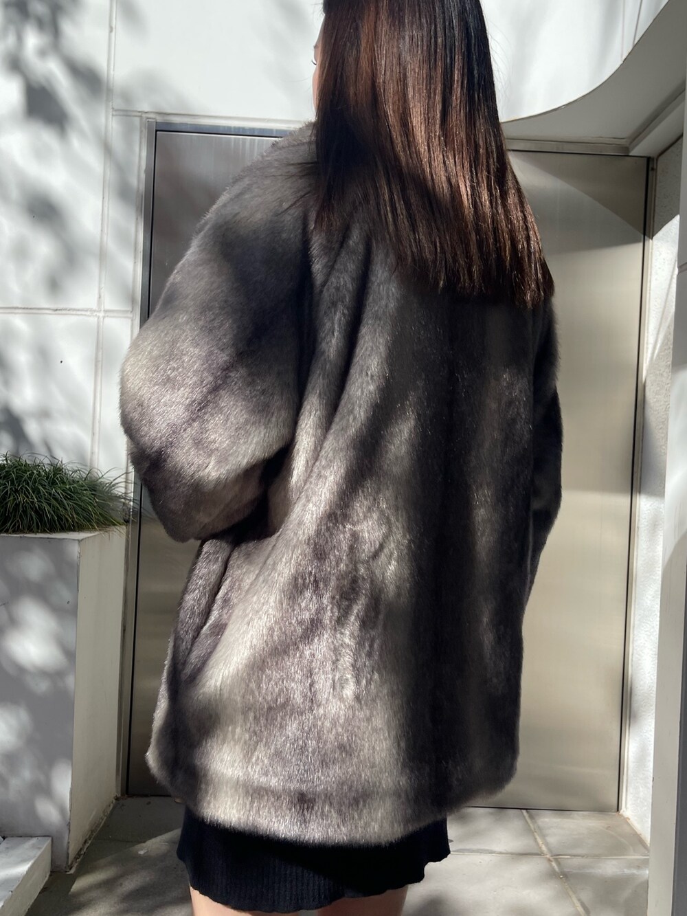 グレー系のその他アウター、ブラック系のワンピース、ブラック系のブーツを着用したレディースの秋コーディネートの6枚目の写真