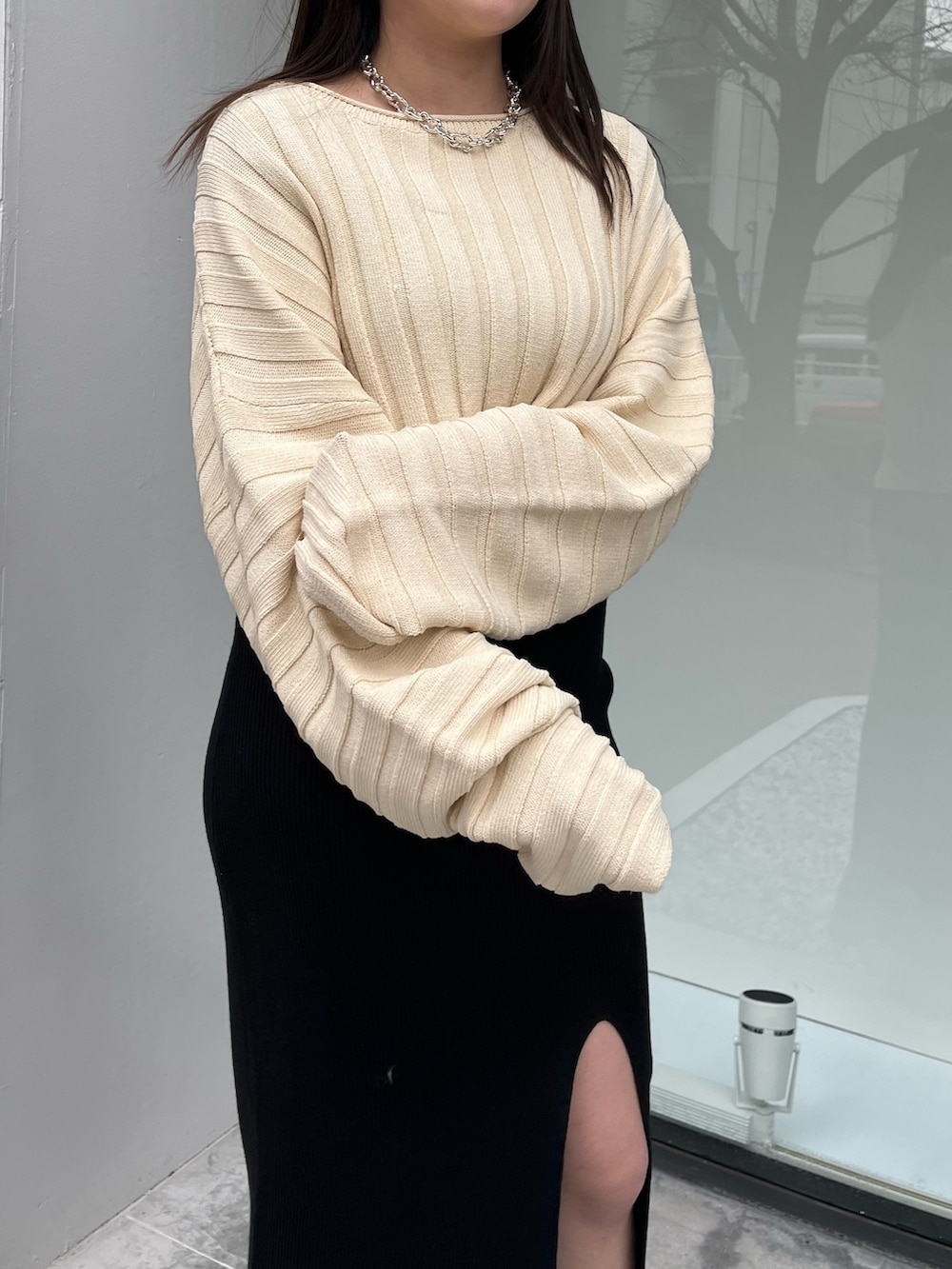 ホワイト系のニット/セーター、ベージュ系のブーツ、ブラック系のワンピースを着用したレディースの春コーディネートの4枚目の写真